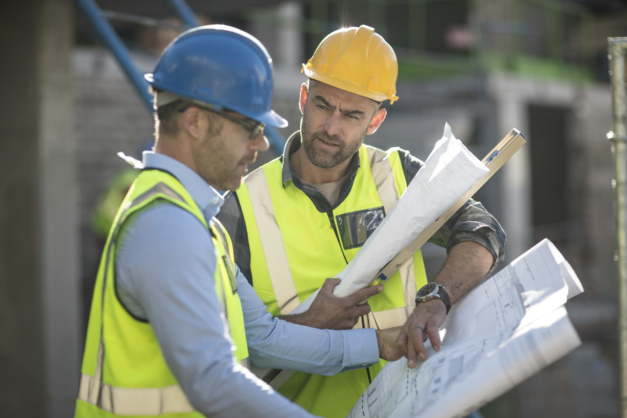 Project manager and construction worker looking at plans